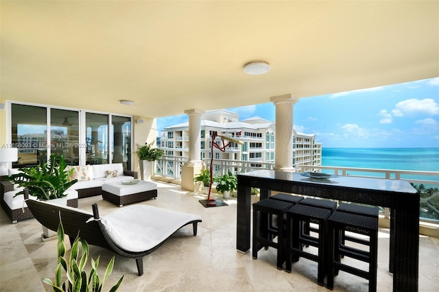 exterior space featuring a balcony, a water view, and an outdoor living space