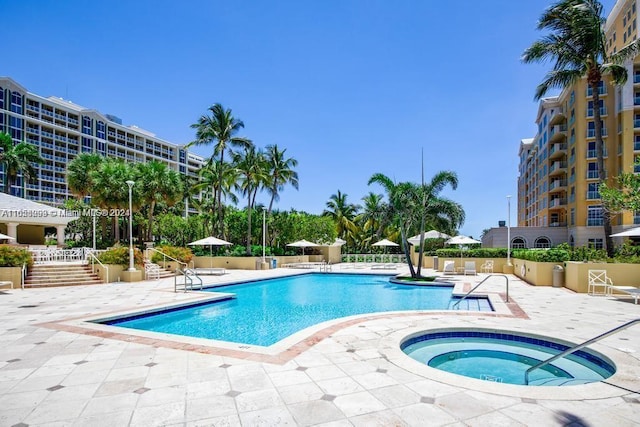 view of pool featuring a hot tub and a patio