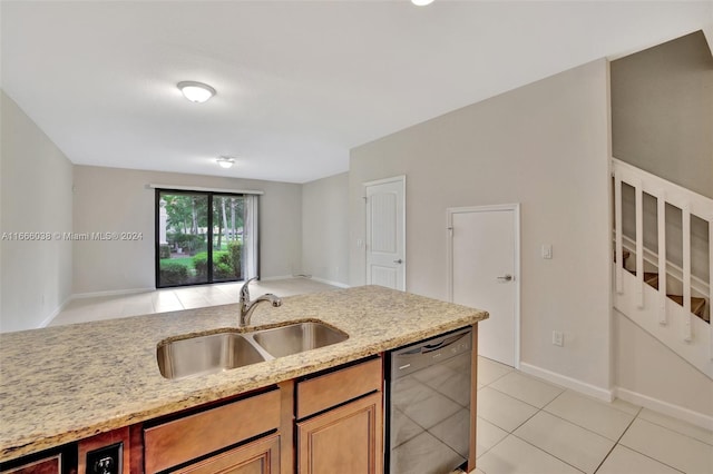 kitchen featuring light stone countertops, dishwasher, light tile patterned floors, and sink