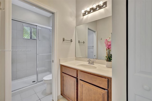 bathroom with tile patterned floors, walk in shower, vanity, and toilet