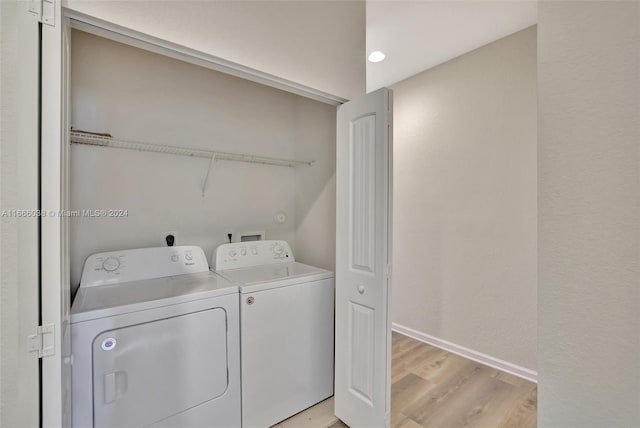 laundry room with light wood-type flooring and separate washer and dryer