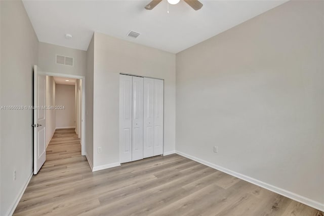 unfurnished bedroom featuring a closet, light hardwood / wood-style floors, and ceiling fan