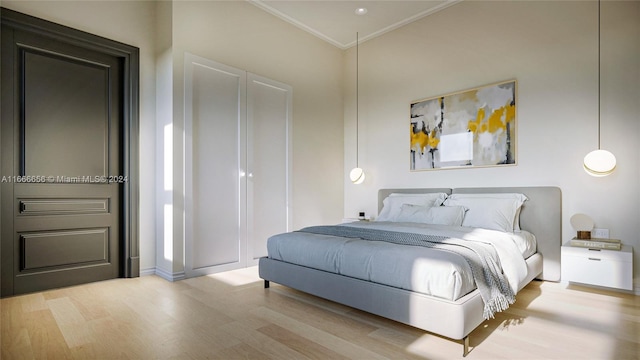 bedroom with ornamental molding and light hardwood / wood-style floors