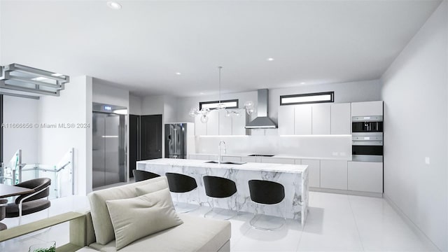 kitchen featuring sink, a kitchen island with sink, wall chimney exhaust hood, white cabinetry, and appliances with stainless steel finishes