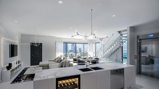 kitchen with dishwasher, sink, a notable chandelier, beverage cooler, and hanging light fixtures