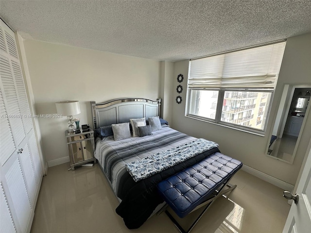 bedroom with light carpet, a textured ceiling, and a closet