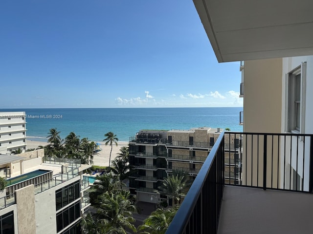 balcony featuring a beach view and a water view