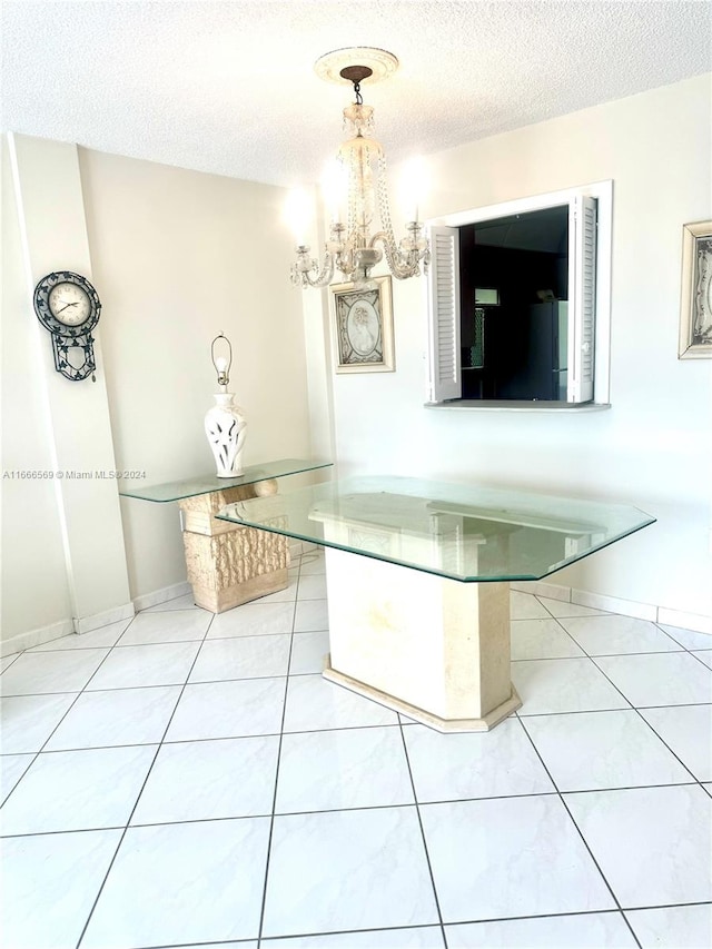 unfurnished dining area with a textured ceiling, tile patterned flooring, and a chandelier