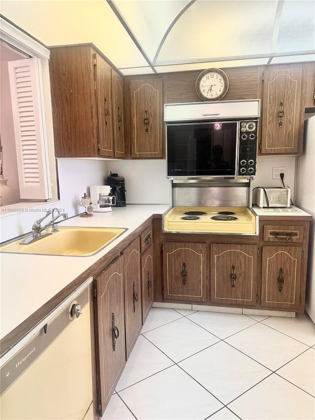 kitchen featuring light tile patterned flooring, stainless steel appliances, and sink