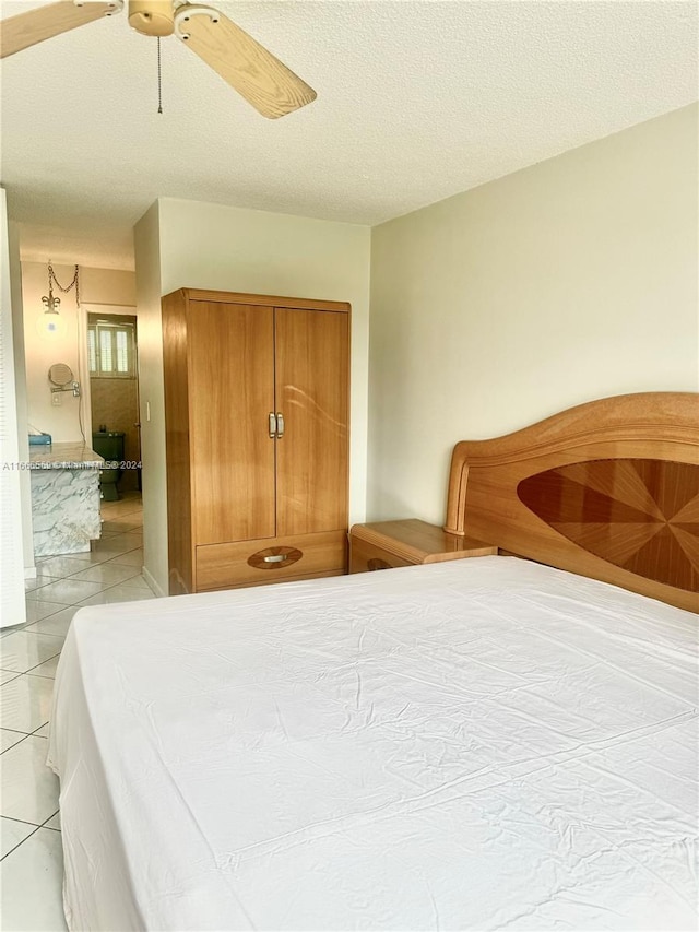 tiled bedroom featuring ceiling fan and a textured ceiling