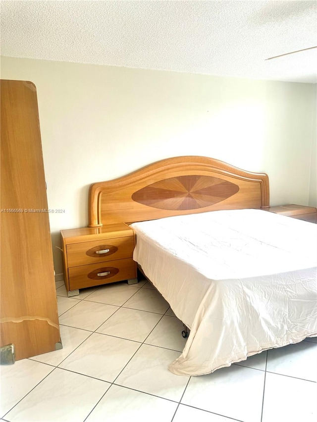 tiled bedroom featuring a textured ceiling