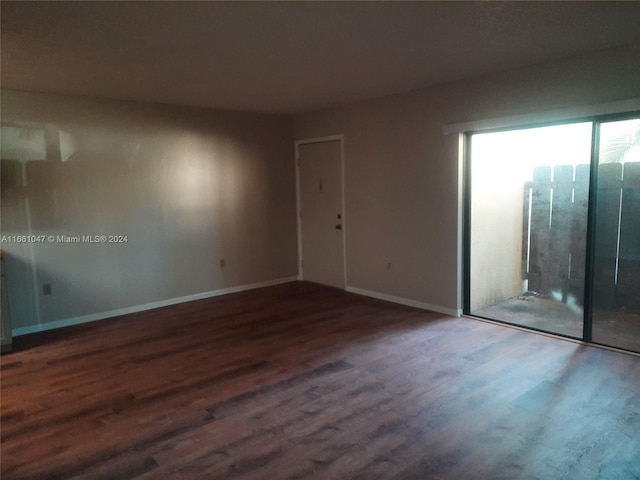 unfurnished room with dark hardwood / wood-style floors