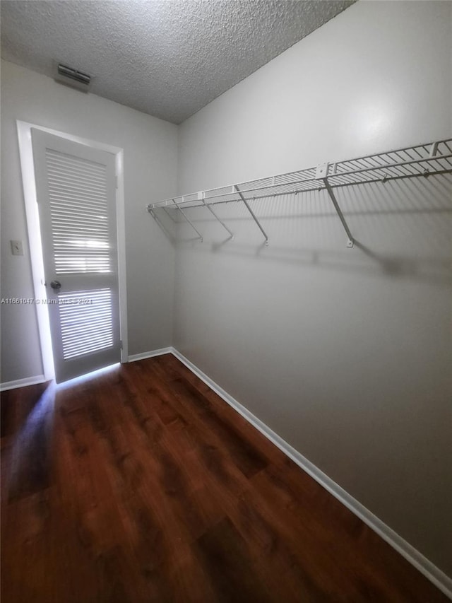 spacious closet featuring dark hardwood / wood-style floors