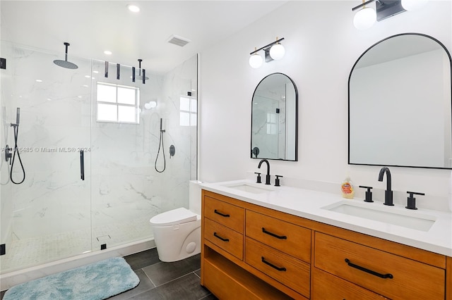 bathroom featuring vanity, toilet, a shower with door, and tile patterned floors