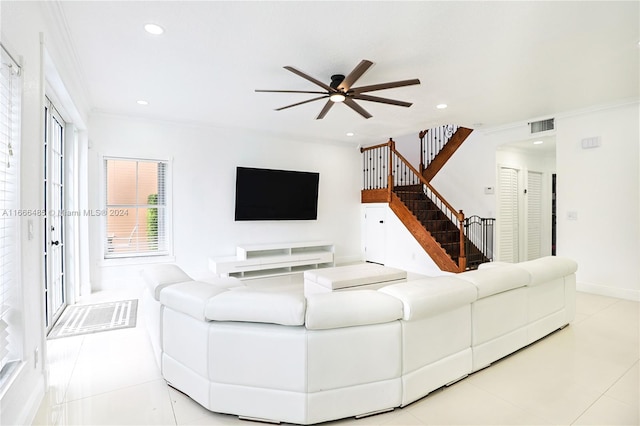 living room featuring light tile patterned floors, ornamental molding, and ceiling fan