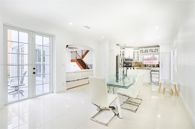 dining room with ceiling fan, sink, light tile patterned floors, french doors, and crown molding