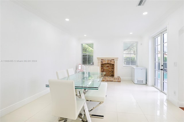 dining room featuring a brick fireplace, plenty of natural light, and ornamental molding