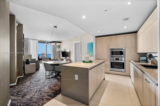 kitchen featuring light brown cabinets, light countertops, modern cabinets, and appliances with stainless steel finishes