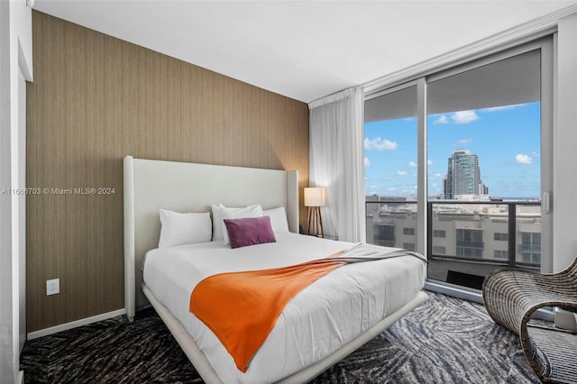 bedroom featuring expansive windows, baseboards, and a view of city