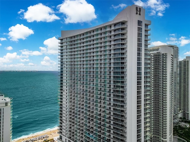 view of building exterior featuring a water view and a view of city