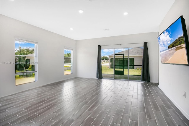 spare room with a healthy amount of sunlight and dark hardwood / wood-style floors