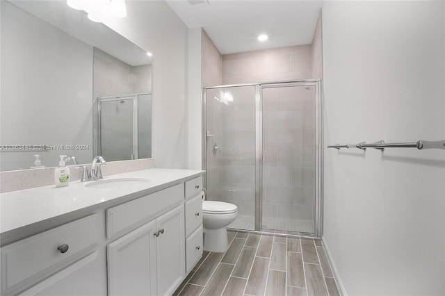 bathroom featuring vanity, toilet, and an enclosed shower