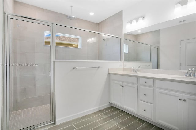 bathroom featuring walk in shower and vanity