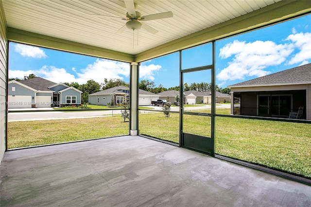 unfurnished sunroom featuring ceiling fan