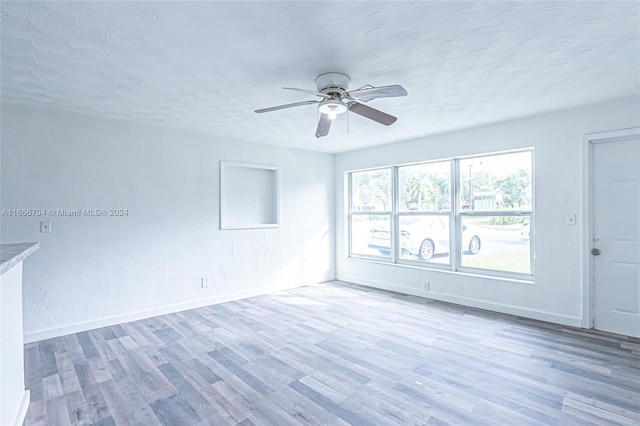 spare room with hardwood / wood-style floors, a textured ceiling, and ceiling fan