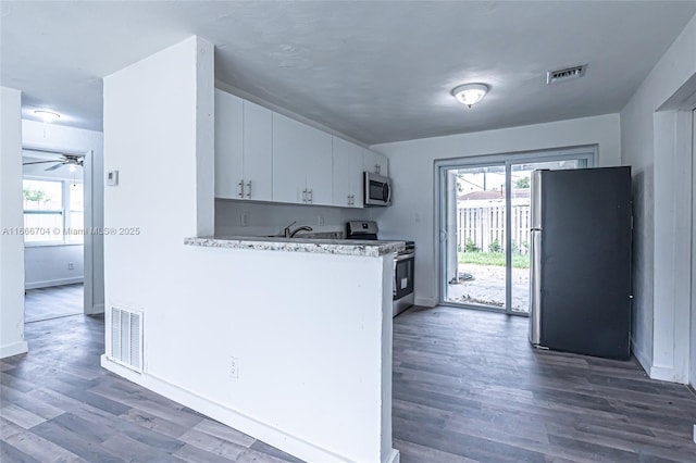 kitchen featuring stainless steel appliances, a wealth of natural light, light countertops, and visible vents