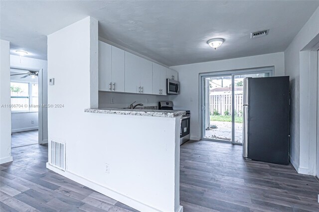 kitchen with ceiling fan, white cabinets, dark wood-type flooring, and appliances with stainless steel finishes