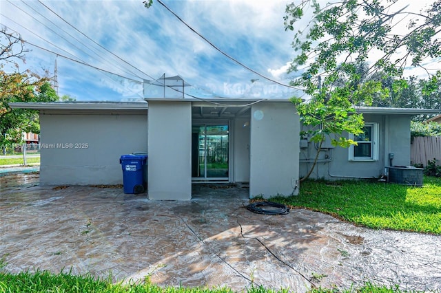 rear view of property with cooling unit, a patio area, and stucco siding