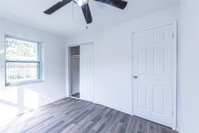 unfurnished bedroom featuring a closet, ceiling fan, and dark wood-type flooring