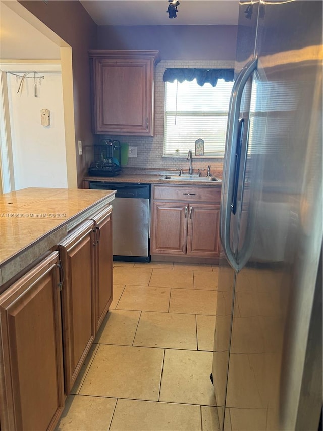 kitchen featuring light tile patterned floors, stainless steel appliances, sink, and tasteful backsplash