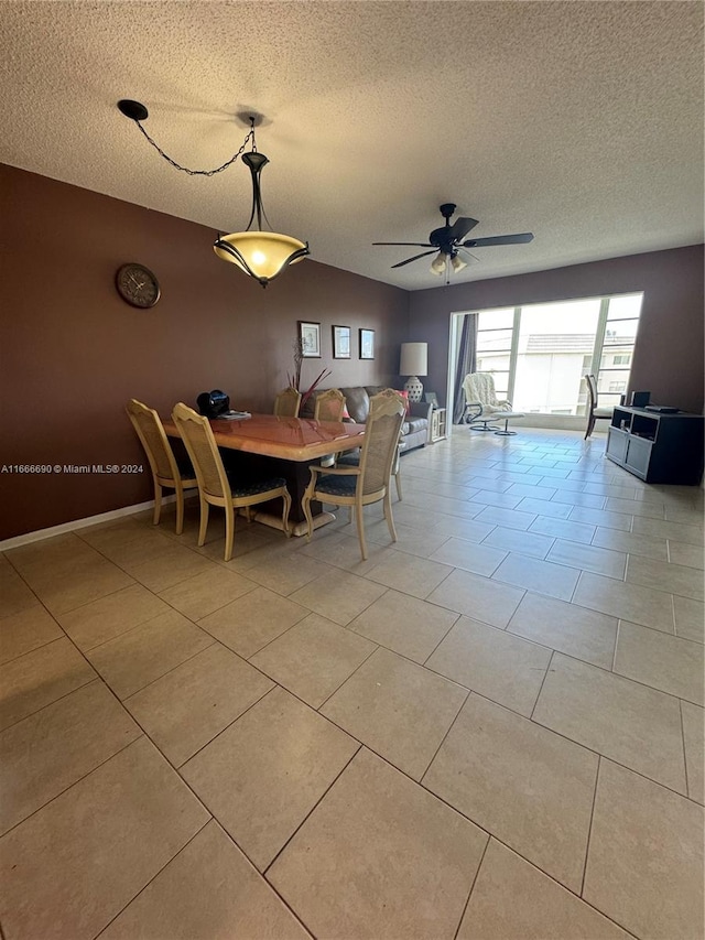 tiled dining space with ceiling fan and a textured ceiling