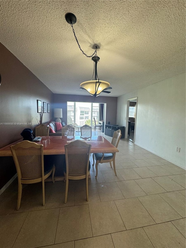 dining area featuring a textured ceiling and light tile patterned floors