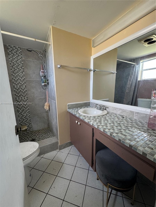 bathroom with walk in shower, vanity, toilet, and tile patterned floors