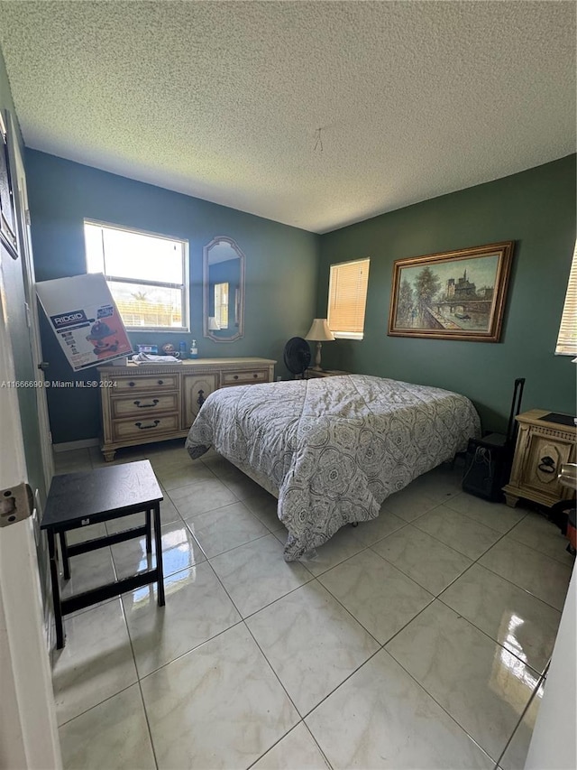 bedroom with a textured ceiling and light tile patterned floors