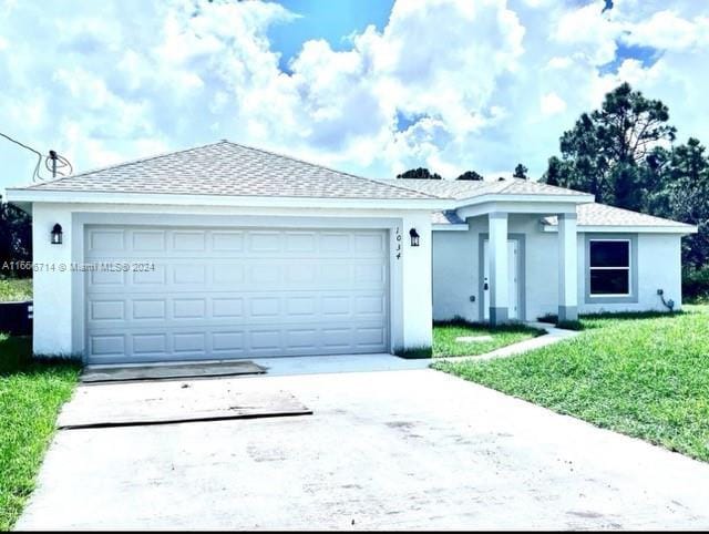 ranch-style house featuring a front lawn and a garage