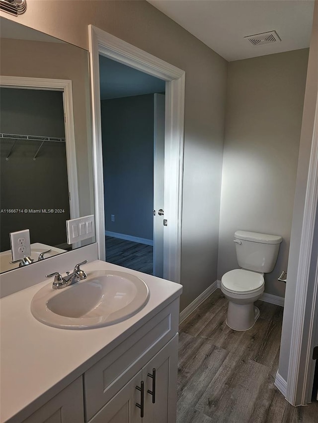 bathroom with vanity, hardwood / wood-style floors, and toilet