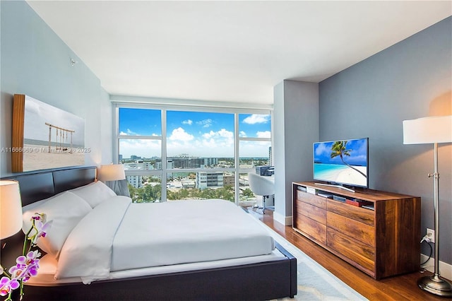 bedroom featuring floor to ceiling windows, multiple windows, and hardwood / wood-style flooring