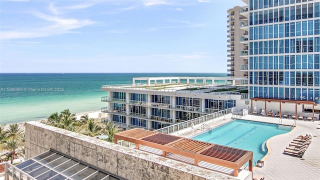 view of pool with a water view and a patio