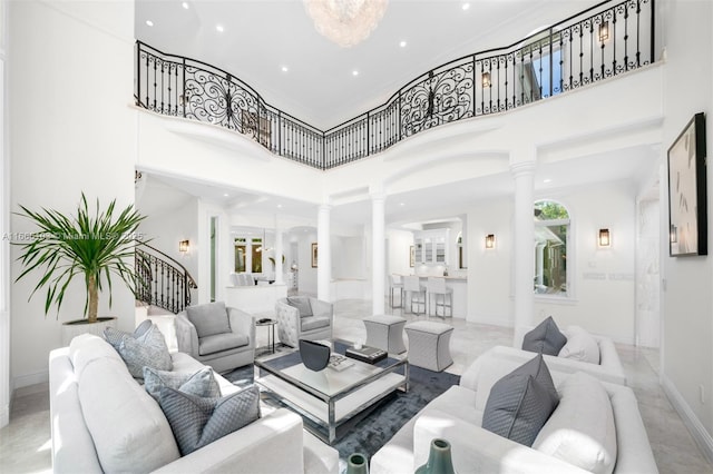 living room featuring decorative columns and a towering ceiling