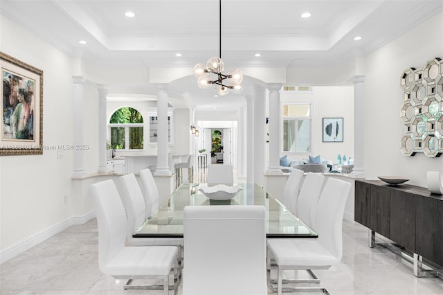 dining room featuring a tray ceiling, crown molding, and a notable chandelier