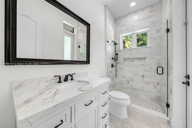 bathroom featuring vanity, toilet, and a shower with shower door