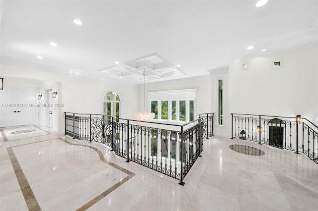 corridor featuring crown molding, coffered ceiling, and an inviting chandelier