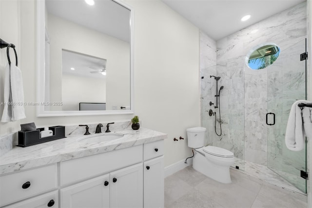 bathroom featuring ceiling fan, vanity, a shower with shower door, and toilet