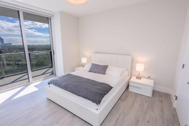 bedroom featuring light hardwood / wood-style floors and access to exterior