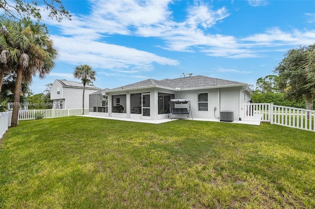 back of property with a patio area, a sunroom, central air condition unit, and a lawn