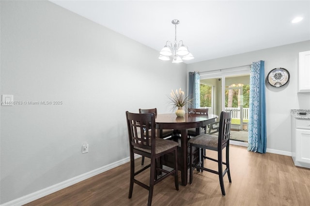 dining area with a notable chandelier, light wood-type flooring, and baseboard heating